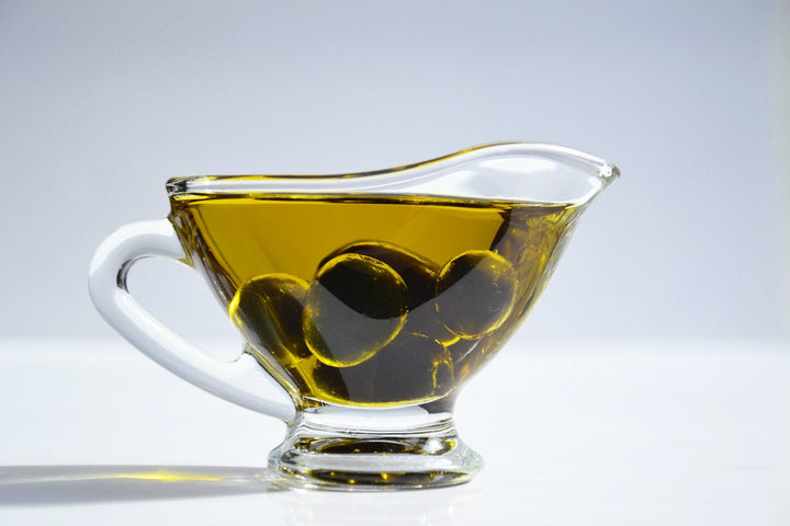 olives and olive oil in clear dish